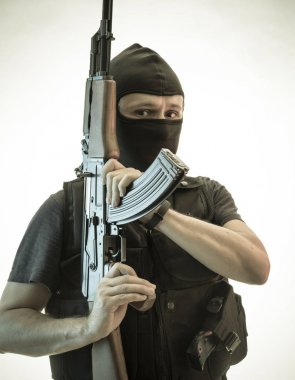 Hırsız, av tüfeği ve kurşun geçirmez yelek ile silahlı adam