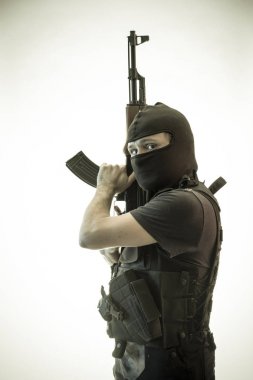 Hırsız, av tüfeği ve kurşun geçirmez yelek ile silahlı adam