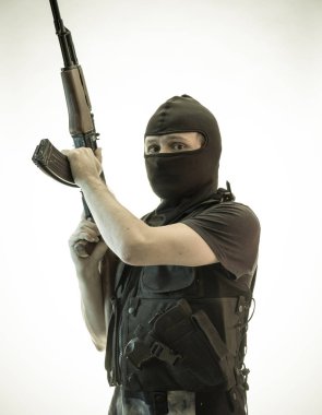 Hırsız, av tüfeği ve kurşun geçirmez yelek ile silahlı adam