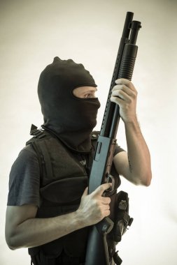 Hırsız, av tüfeği ve kurşun geçirmez yelek ile silahlı adam