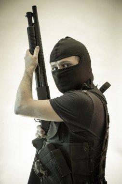 Hırsız, av tüfeği ve kurşun geçirmez yelek ile silahlı adam