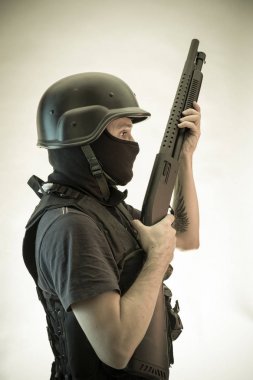 Hırsız, av tüfeği ve kurşun geçirmez yelek ile silahlı adam