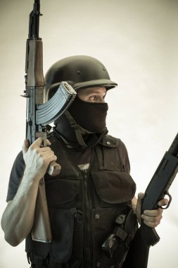 Hırsız, av tüfeği ve kurşun geçirmez yelek ile silahlı adam