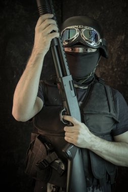 Hırsız, av tüfeği ve kurşun geçirmez yelek ile silahlı adam