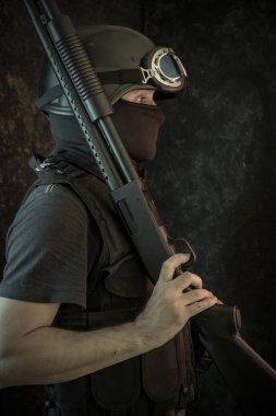 Hırsız, av tüfeği ve kurşun geçirmez yelek ile silahlı adam