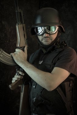 Hırsız, av tüfeği ve kurşun geçirmez yelek ile silahlı adam
