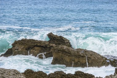 kayalara karşı azgın ve öfkeli deniz kırma, İspanya'nın kuzeyinde Cantabriye Denizi