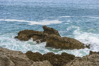 kayalara karşı azgın ve öfkeli deniz kırma, İspanya'nın kuzeyinde Cantabriye Denizi
