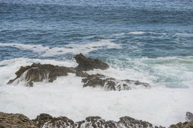 kayalara karşı azgın ve öfkeli deniz kırma, İspanya'nın kuzeyinde Cantabriye Denizi