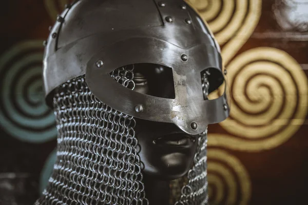 Weapons Viking helmet with chain mail of iron on red shield of wood and golden triskel