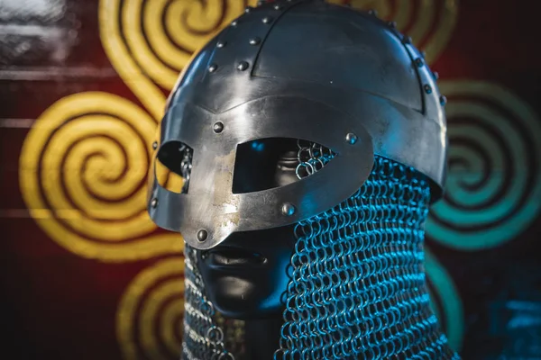 Soldier Viking helmet with chain mail of iron on red shield of wood and golden triskel