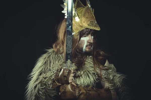 バイキング ヘルメットと戦争絵画を持つスカンジナビアの戦士は 剣と動物の皮のケープを身に着けている — ストック写真
