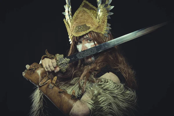 バイキング ヘルメットと戦争絵画を持つスカンジナビアの戦士は 剣と動物の皮のケープを身に着けている — ストック写真