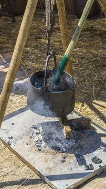 İspanya'da bir ortaçağ fuarında renkli boyalar ile bir kazan kumaş ve yün renkli el yapımı boyama