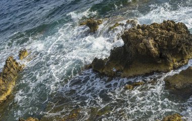 Yaz cliff Akdeniz yanında, güçlü dalgalar kayalar ile break ve mavi ve turkuaz renkleri ile birlikte denizin köpük bırakın.