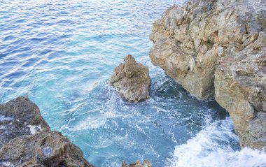 Yaz cliff Akdeniz yanında, güçlü dalgalar kayalar ile break ve mavi ve turkuaz renkleri ile birlikte denizin köpük bırakın.