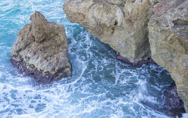 Yaz cliff Akdeniz yanında, güçlü dalgalar kayalar ile break ve mavi ve turkuaz renkleri ile birlikte denizin köpük bırakın.