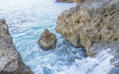 Yaz cliff Akdeniz yanında, güçlü dalgalar kayalar ile break ve mavi ve turkuaz renkleri ile birlikte denizin köpük bırakın.