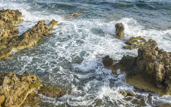 地中海旁边的夏季悬崖 强烈的海浪与岩石断裂 留下蓝色和绿松石色 以及大海的泡沫 — 图库照片