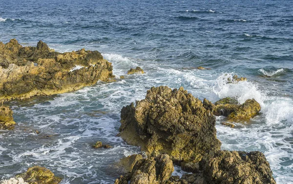 夏日悬崖旁的地中海 强烈的波浪打破与岩石和留下蓝色和绿松石的颜色连同泡沫的海 — 图库照片