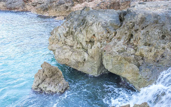 地中海の隣の夏の崖 強い波は岩で壊れ 海の泡と一緒に青とターコイズ色を残します — ストック写真