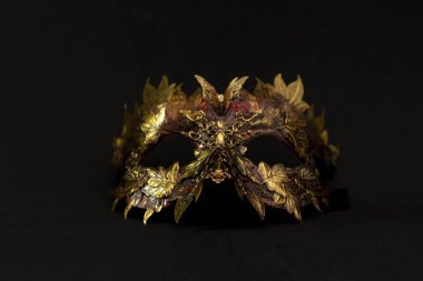 Venetian mask in gold and red with metallic pieces in the form of leaves. original and unique design, handmade crafts clipart