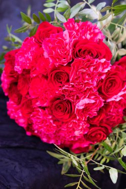 Masanın üzerinde yuvarlak kırmızı güller dantel kumaş ve düğün süslemeleri.