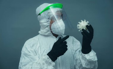 Covid19, koruyucu maskeli, gözlüklü ve hijyenik maskeli hemşire. Gri ve nötr arkaplan üzerinde koronavirüs ve tedavi kavramı