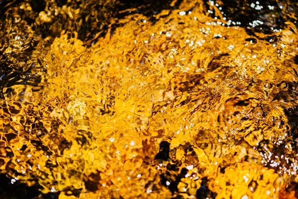 Autumnal golden yellow blurry abstract water background. Formed from sunny reflections of forest trees and movement in a river. With copy space for your text, Wallpaper, Backdrop, Water fall, Nature.