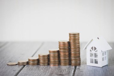 Para madeni para yığınının adım büyüme modeli beyaz ev ahşap masa üzerinde büyüyor. Gayrimenkul yatırım ve house mortgage mali kavramı, eve korumak, sigorta. Metniniz için kopya alanı ile.