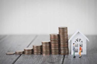 Minyatür insanlar küçük bir rakam sikke para yığını adım modeli beyaz ev, gayrimenkul yatırım ve house mortgage mali kavramı, büyüme büyüyen kadar ayakta eve korumak, sigorta. Kopya alanı ile.