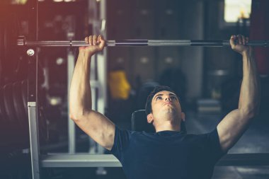 Beyaz yakışıklı genç ve büyük kas spor içinde uygun. Genç adam bir spor salonunda bir egzersiz dersi sırasında dumbbell tutarak. Sağlıklı spor yaşam tarzı, Fitness kavramı.
