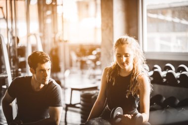 Uygun güzel genç kadın beyaz çekici fitness kadın egzersiz halter salonunda antrenör tarafından ile. Sağlıklı, spor, yaşam tarzı, Fitness kavramı.