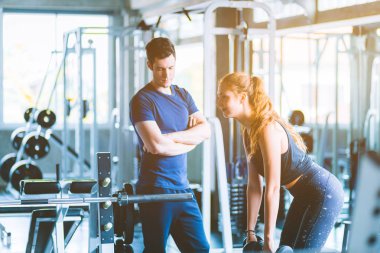 Uygun güzel genç kadın beyaz çekici fitness kadın egzersiz halter salonunda antrenör tarafından ile. Sağlıklı, spor, yaşam tarzı, Fitness kavramı.