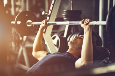 Beyaz yakışıklı genç ve büyük kas spor içinde uygun. Genç adam bir spor salonunda bir egzersiz dersi sırasında dumbbell tutarak. Sağlıklı spor yaşam tarzı, Fitness kavramı.