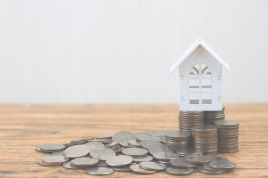 Para madeni para yığınının adım büyüme modeli beyaz ev ahşap masa üzerinde büyüyor. Gayrimenkul yatırım ve house mortgage mali kavramı, eve korumak, sigorta. Metniniz için kopya alanı ile.