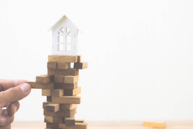 Ahşap blok ahşap blok oyun modeli Beyaz Saray'la tutan el. Yatırım risk ve belirsizlik Emlak Konut piyasası. Gayrimenkul yatırım ve ev mali kavramı mortgage. Kopya alanı.