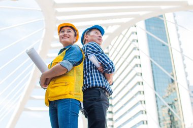 Takım ortaklar ayakta ve bina dışında muayene holding ile kamera giyim kask için seyir mühendis portresi. Mühendislik araçları ve inşaat kavramı. kopya alanı ile