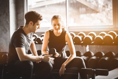 Uygun güzel genç kadın beyaz çekici fitness kadın egzersiz halter salonunda antrenör tarafından ile. Sağlıklı, spor, yaşam tarzı, Fitness kavramı.
