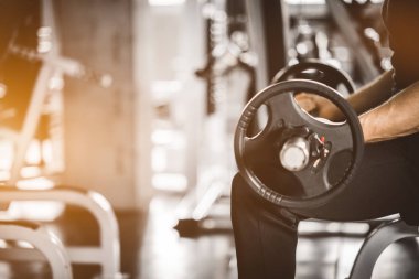 Kafkasyalı yakışıklı genç bir adam ve spor giyim sektöründe kaslı. Spor salonunda egzersiz yaparken dambılı tutan genç bir adam. Sağlıklı spor yaşam tarzı, spor konsepti. Metnin için kopyalama alanı ile.
