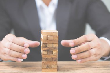 İşadamı el ahşap blok koymak. Yatırım risk ve belirsizlik Emlak Konut piyasası. Gayrimenkul yatırım ve ev mali kavramı mortgage. i. kopya alanı metni.