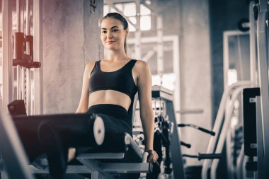 Güzel genç kadın egzersiz egzersiz jimnastik salonu makinedeki uygun. Memnun gülümseyen kız onu eğitim süreci ile keyfini çıkarın. Fitness, sağlıklı, spor, yaşam kavramı