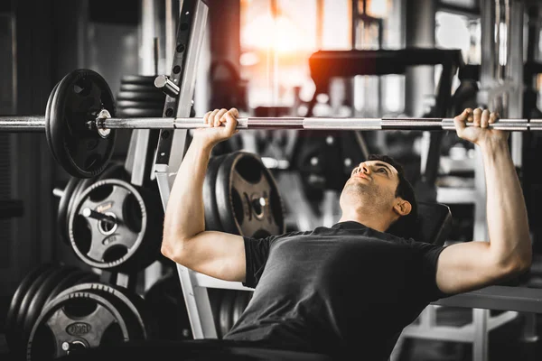 Kafkasyalı yakışıklı genç bir adam ve spor giyim sektöründe kaslı. Spor salonunda egzersiz yaparken dambılı tutan genç bir adam. Sağlıklı spor yaşam tarzı, spor konsepti. Metnin için kopyalama alanı ile.