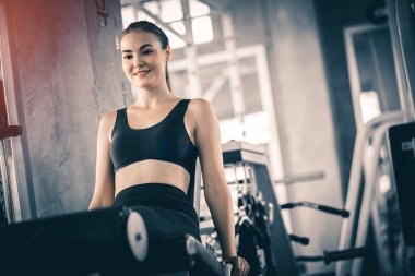 Güzel genç kadın egzersiz egzersiz jimnastik salonu makinedeki uygun. Memnun gülümseyen kız onu eğitim süreci ile keyfini çıkarın. Fitness, sağlıklı, spor, yaşam kavramı