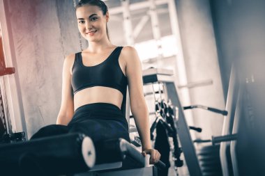 Güzel genç kadın egzersiz egzersiz jimnastik salonu makinedeki uygun. Memnun gülümseyen kız onu eğitim süreci ile keyfini çıkarın. Fitness, sağlıklı, spor, yaşam kavramı