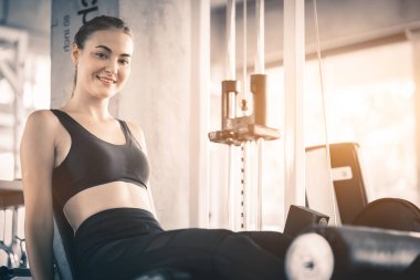 Güzel genç kadın egzersiz egzersiz jimnastik salonu makinedeki uygun. Memnun gülümseyen kız onu eğitim süreci ile keyfini çıkarın. Fitness, sağlıklı, spor, yaşam kavramı