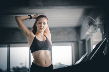 Genç kadın çekici fitness egzersiz egzersiz jimnastik salonu. Kas germe ve fitness spor kulübünde makine treadmill egzersiz sonrası rahatlatıcı kadın.