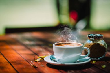 Sıcak kahve latte kapuçino sarmal köpük kahve dükkanı Cafe vintage renk tonu filtre arka plan ile ahşap masa üzerinde. Metniniz için kopya alanı ile.