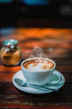Sıcak kahve latte kapuçino sarmal köpük kahve dükkanı Cafe vintage renk tonu filtre arka plan ile ahşap masa üzerinde. Metniniz için kopya alanı ile. Renk tonu efekti