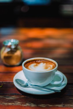 Sıcak kahve latte kapuçino sarmal köpük kahve dükkanı Cafe vintage renk tonu filtre arka plan ile ahşap masa üzerinde. Metniniz için kopya alanı ile. Renk tonu efekti